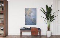a blue and gold abstract painting hangs on a wall in a living room