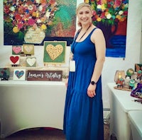 a woman in a blue dress standing in front of art